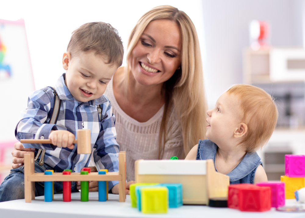 mulher e dois filhos pequenos brincando juntos