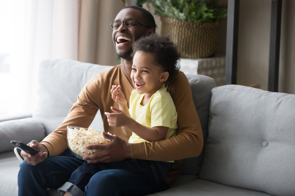 pai e filho assistindo a um filme em casa